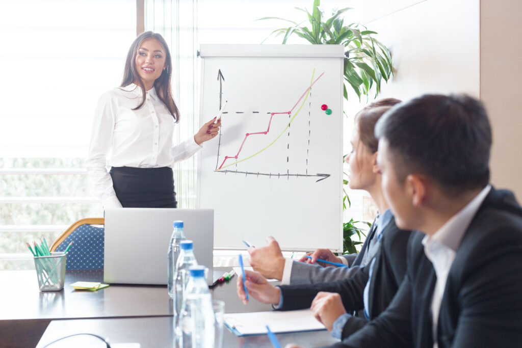 A confident business professional discussing projections with her clients.